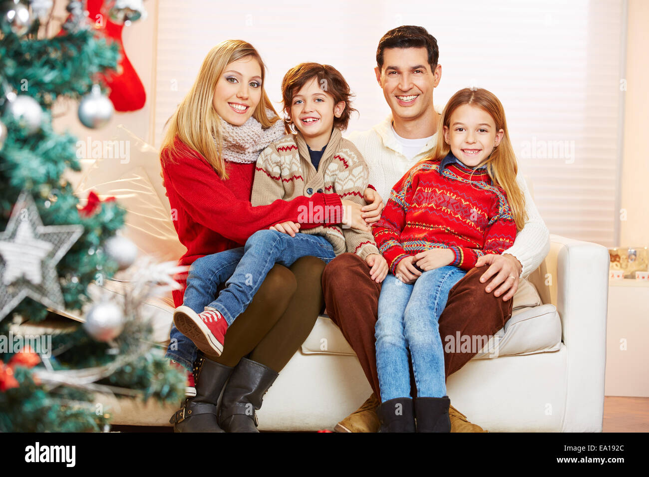 La famiglia felice e i bambini festeggiano il Natale con un albero di natale Foto Stock