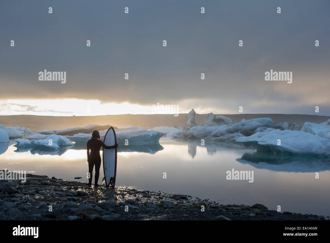 Donna con la tavola da surf, Jokulsarlon laguna glaciale, Skaftafell National Park, Islanda Foto Stock