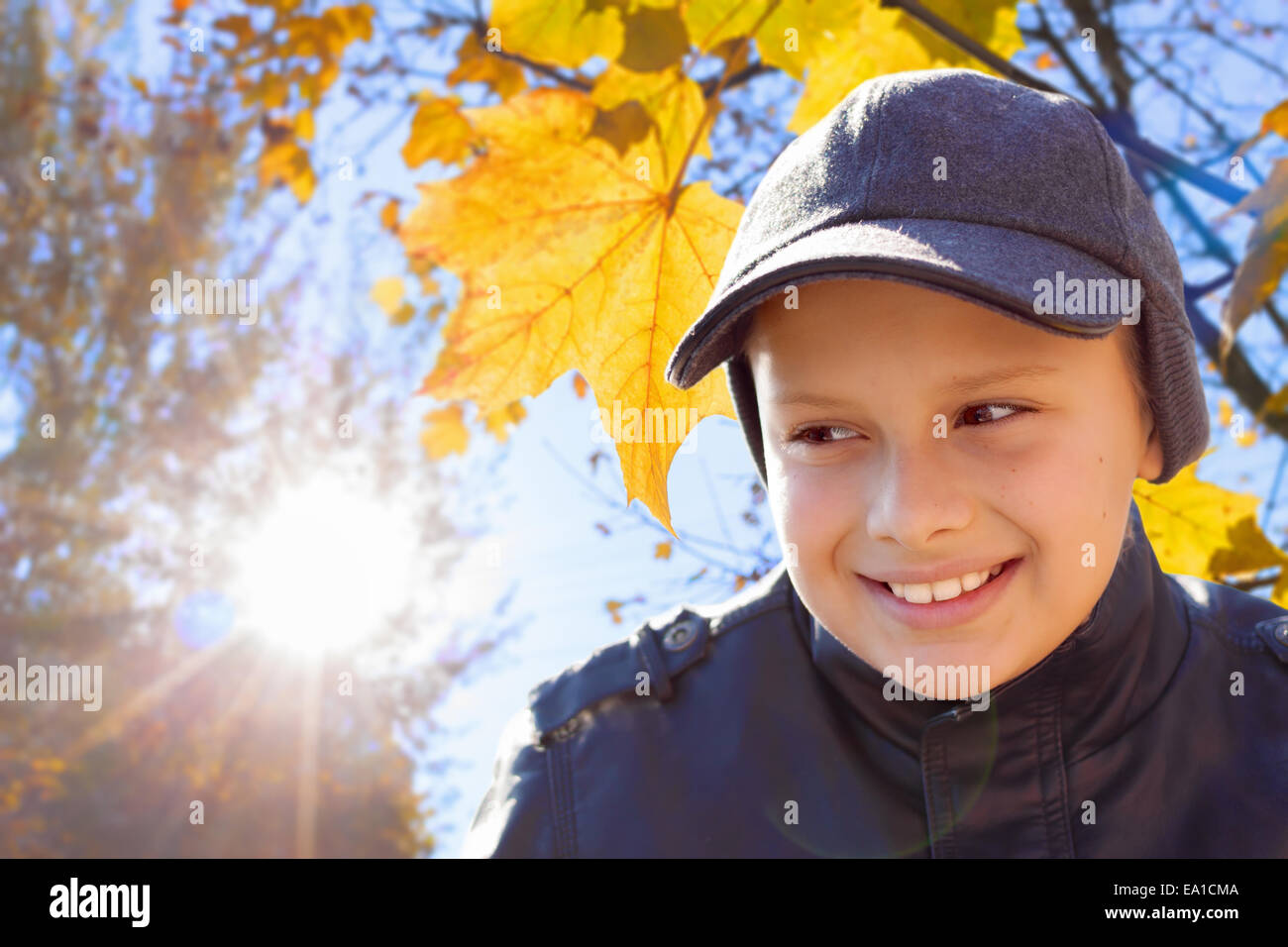 Bambino ragazzo sorriso di sole foglie di autunno Foto Stock