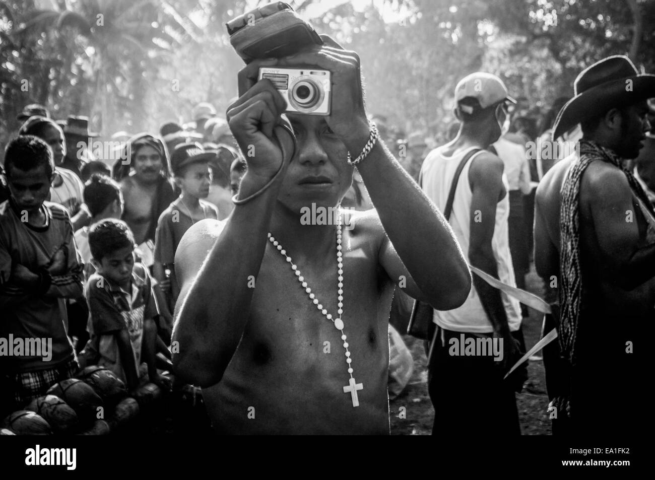 Un giovane che scatta fotografie durante un evento culturale nel villaggio di Lewotolok sul pendio del vulcano Lewotolok nell'isola di Lembata, Indonesia. Foto Stock