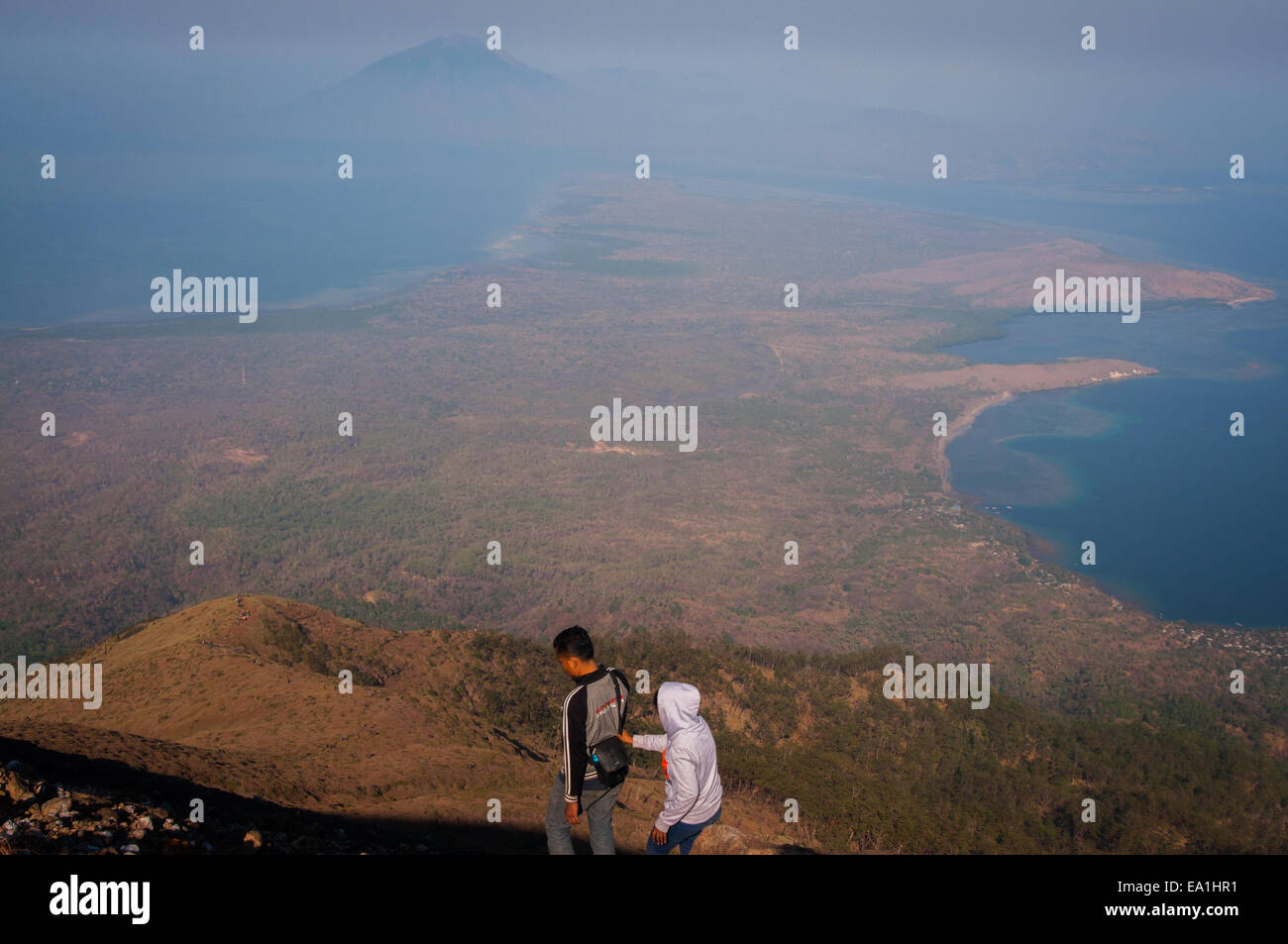 La gente cammina insieme mentre scende dalla cima del vulcano del Monte Lewotolok nell'isola di Lembata, Nusa Tenggara orientale, Indonesia. Foto Stock