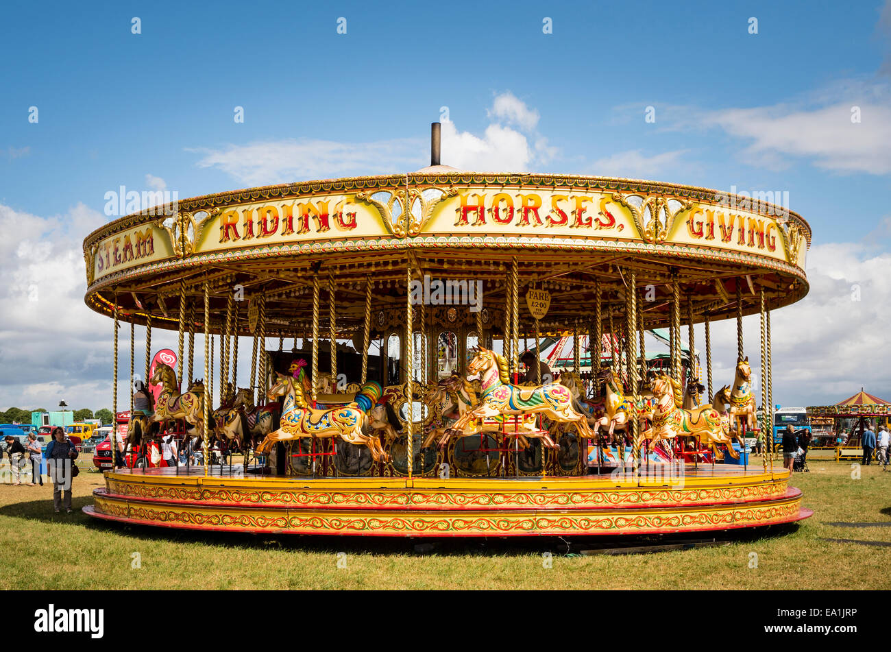 Rotonda con vapore azionato cavalli al galoppo in un paese in fiera nel Regno Unito Foto Stock