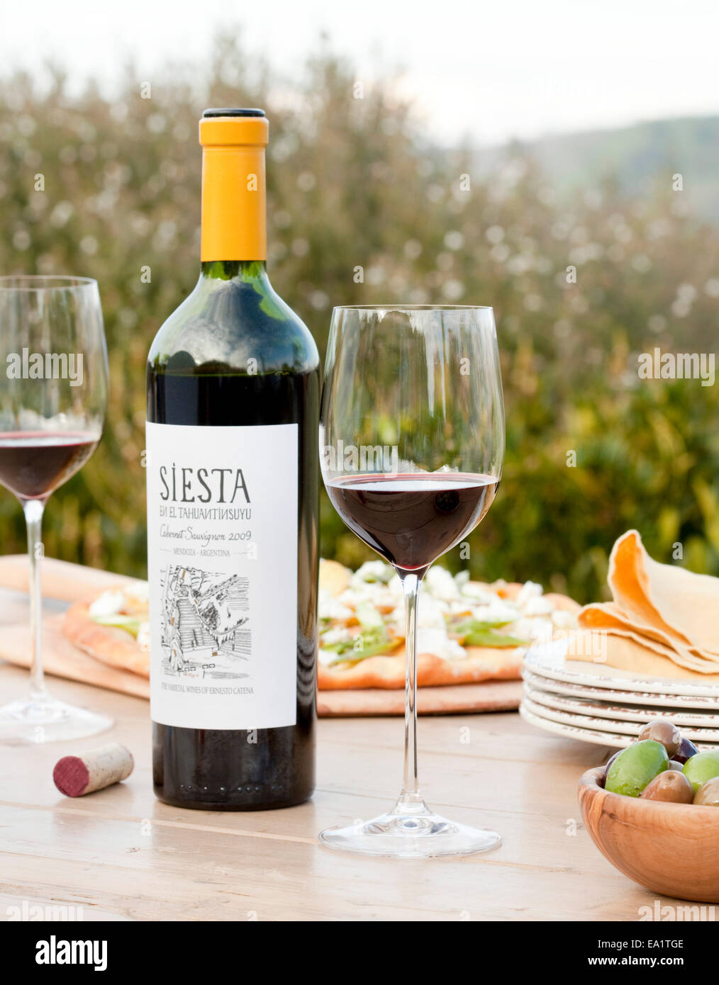 Vino rosso e bottiglia di vetro sul tavolo all'aperto Foto Stock