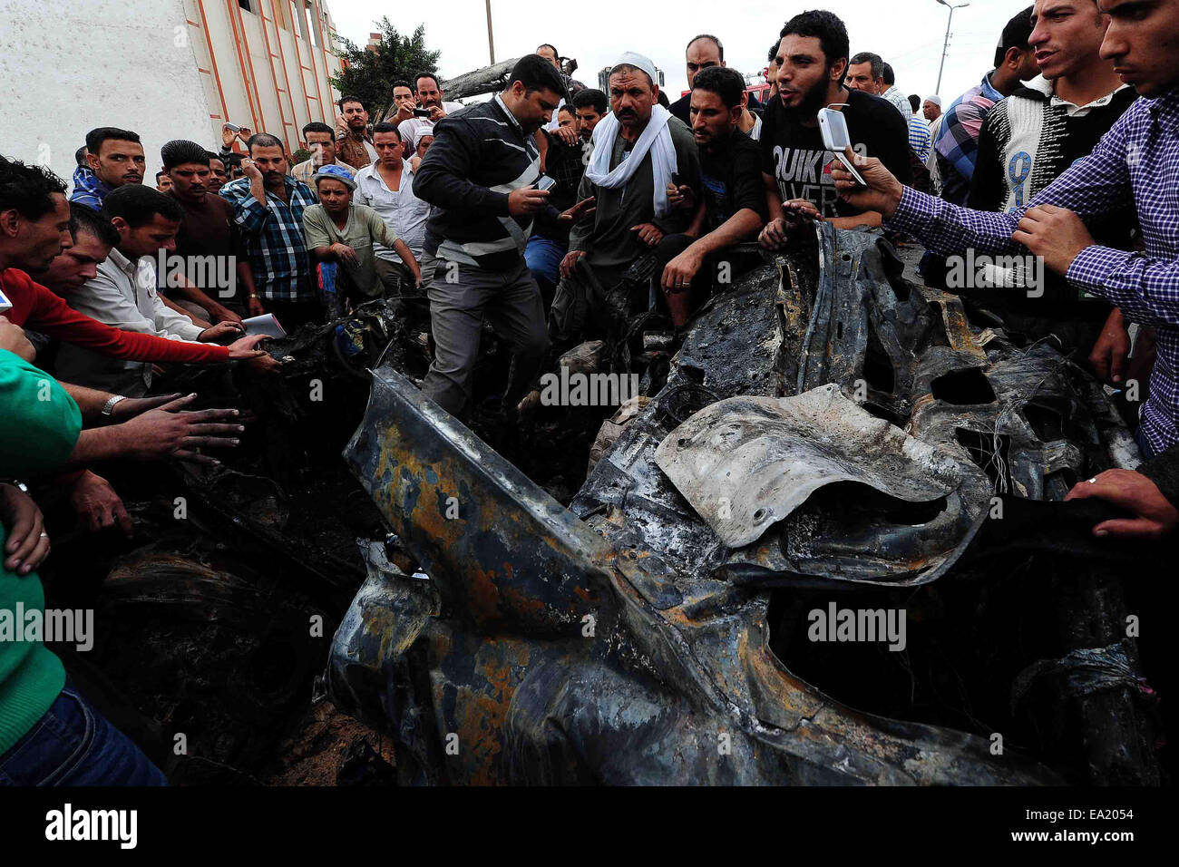 Damanhur, Damanhur, Egitto. 5 Novembre, 2014. Gli egiziani guardare il relitto di un olocausto scuola bus dopo che si è schiantato in Damanhur Novembre 5, 2014. Almeno 16 persone, soprattutto bambini, sono stati uccisi il Mercoledì quando il bus si è schiantato in tre altri veicoli sulle strade del deserto nel Delta del Nilo a nord del Cairo, alla televisione di stato detto. Diciotto persone sono stati anche feriti in crash e trasportato in ospedale, una salute locale ministero ufficiale detto © Stringer/immagini APA/ZUMA filo/Alamy Live News Foto Stock