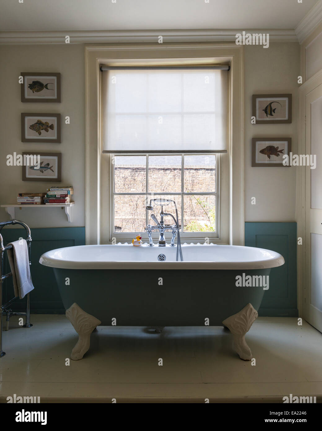 Free standing roll top bagno in bagno con stampe incorniciate di pesce Foto Stock