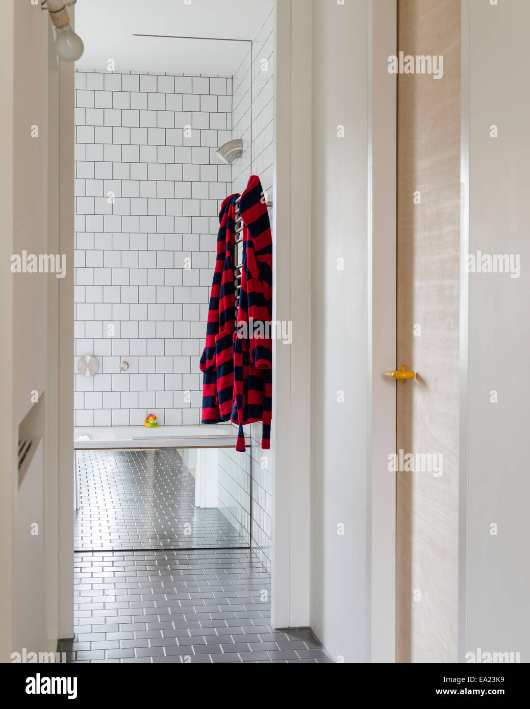 Visualizza in basso corridoio a bagno con pareti bianche piastrelle Foto Stock
