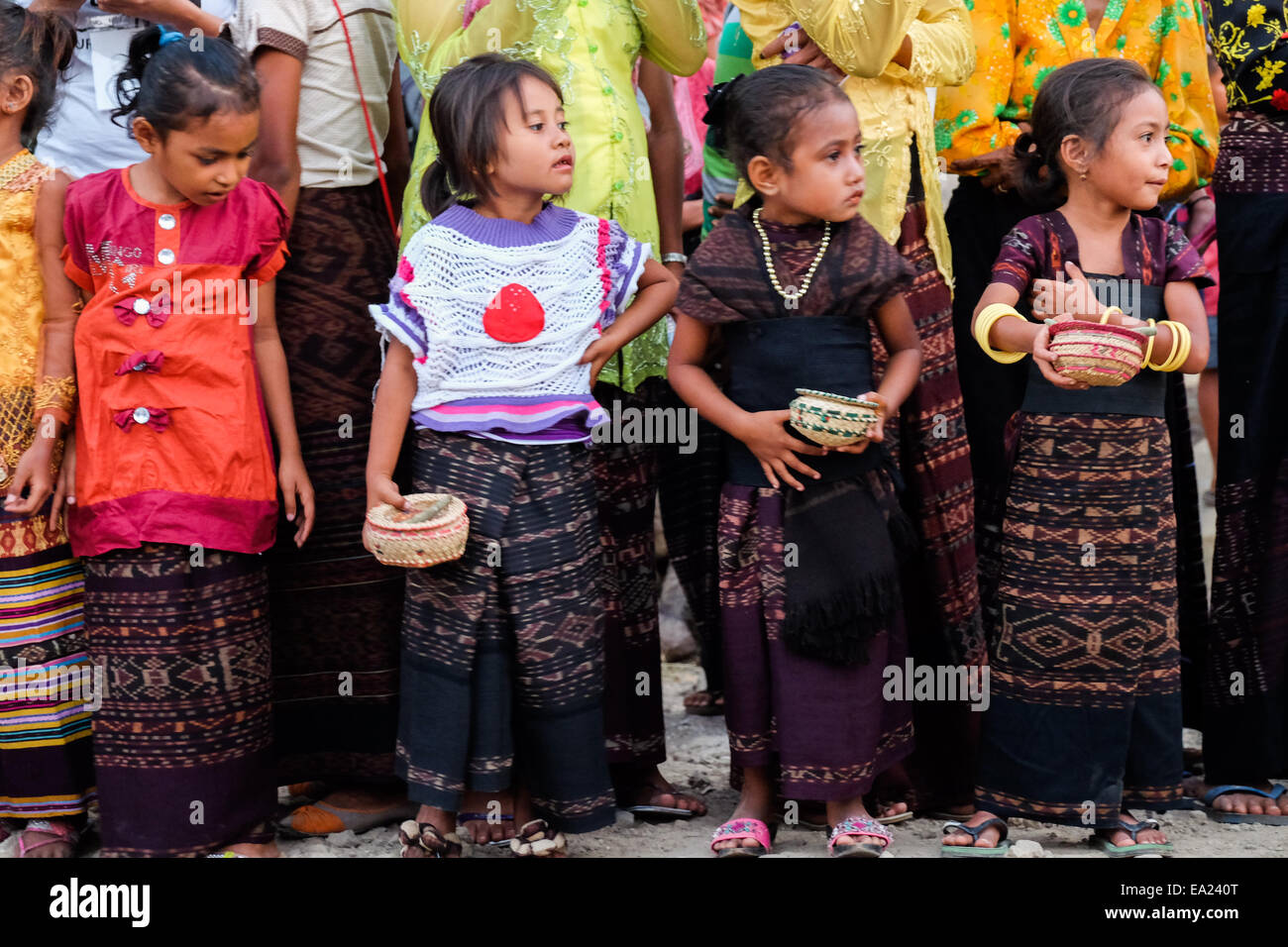 Bambini attendere per gli ospiti in arrivo durante una tradizionale cerimonia di benvenuto nel villaggio Lamagute, Lembata, Indonesia. Foto Stock