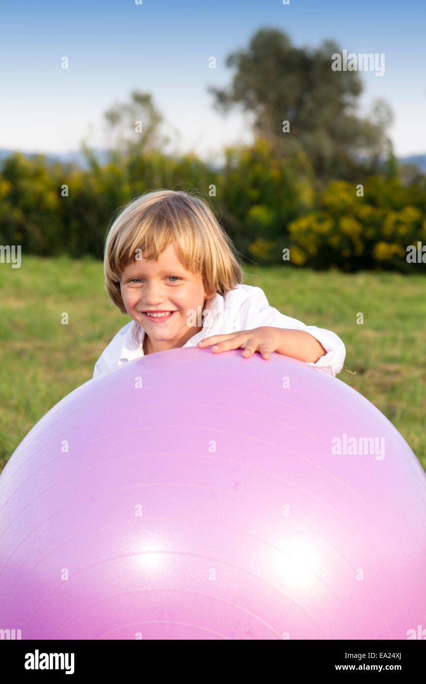 Giovane ragazzo carino giocare con grande medicina pesanti montare la sfera Foto Stock