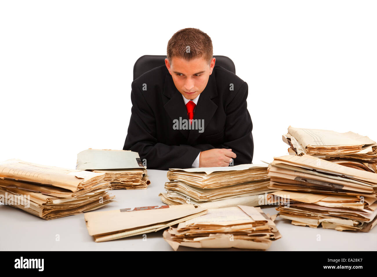 Business man guardando l'enorme quantità di documenti su tavola Foto Stock