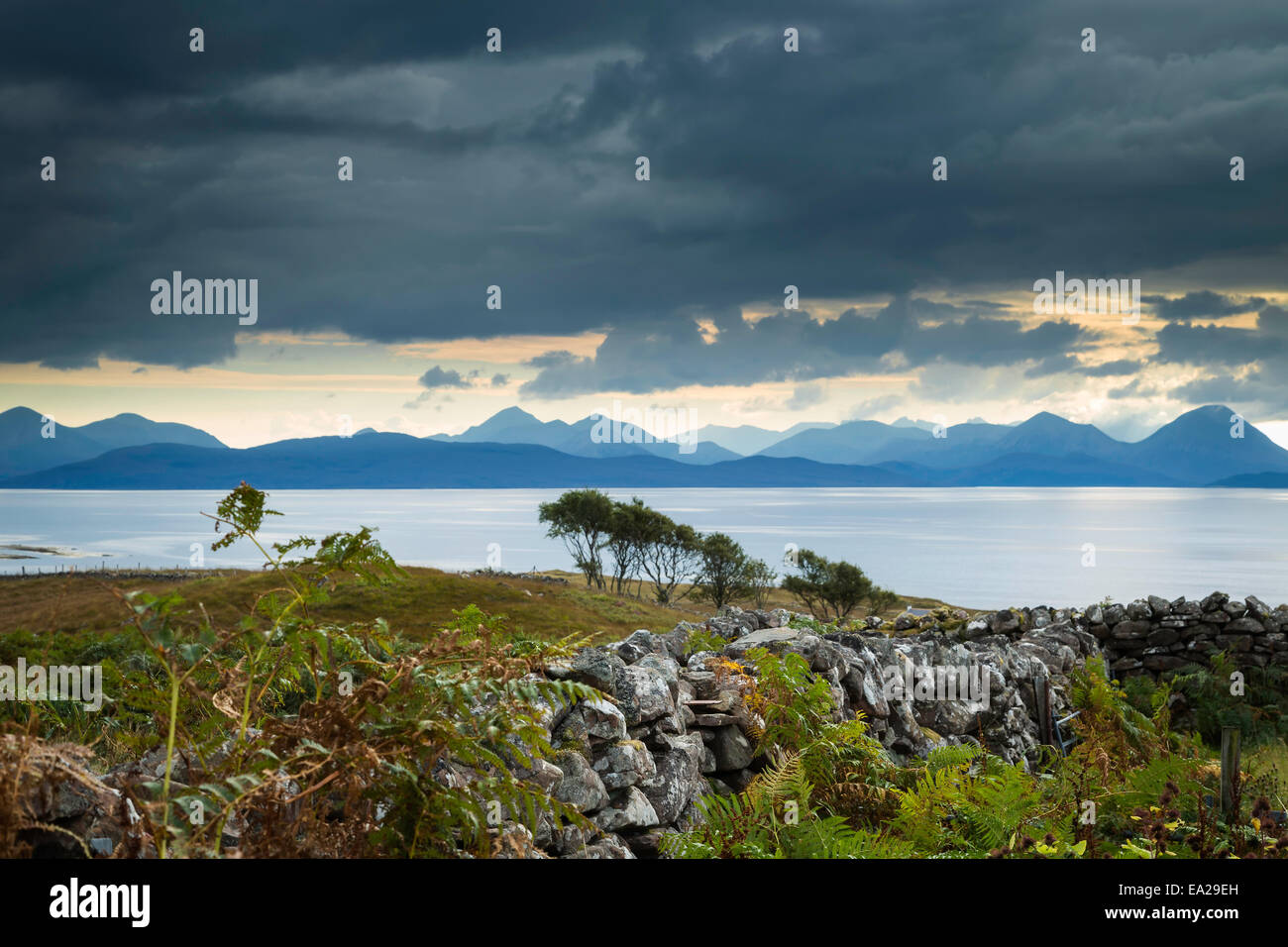 Asciugare la parete in pietra conduce al suono interno con le isole di Raasay e Skye in background, Applecross peninsular, Scozia Foto Stock