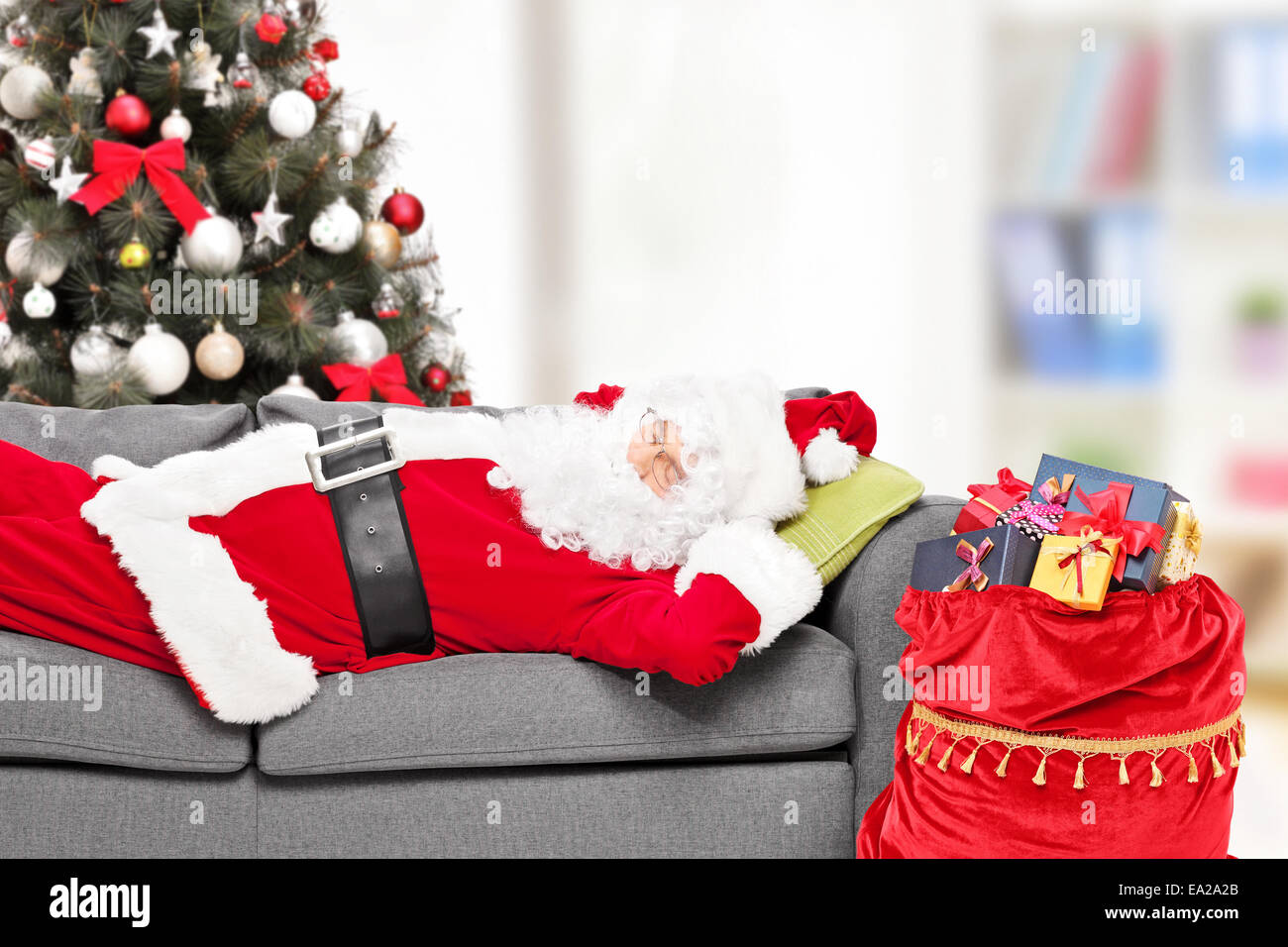 Dormire Nella Casa Di Babbo Natale.Santa Claus Dormire Con Un Albero Di Natale Su Un Divano A Casa Con Un Sacco Di Regali Accanto A Lui Foto Stock Alamy