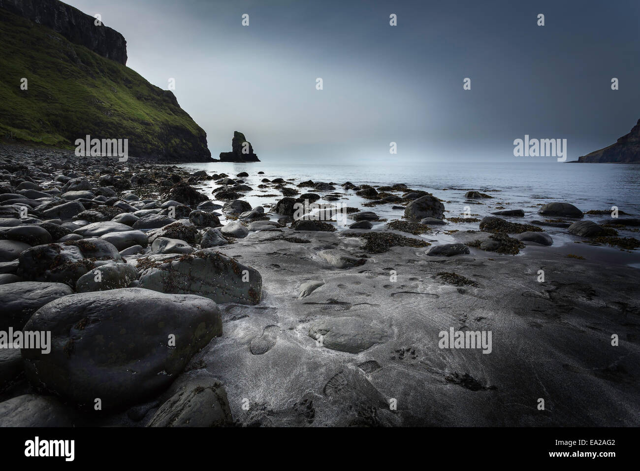 Boulder disseminata litorale con stack di mare, Talisker Bay, Isola di Skye in Scozia Foto Stock