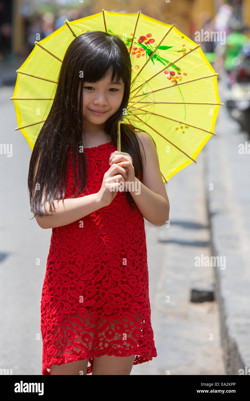 Giovane ragazza camminare con carta ombrello in HoiAn Vietnam Foto Stock