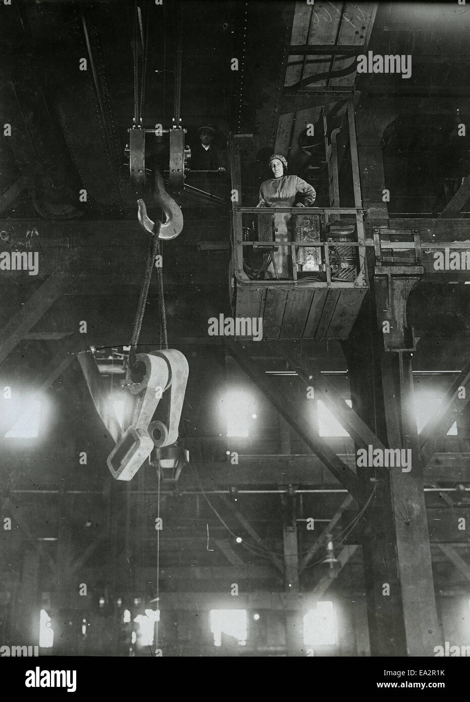 Una fotografia di una donna che gestisce una gru O.E.T. che mostra il ruolo delle donne nei settori industriale ed edile. L'immagine evidenzia l'abilità e la precisione necessarie per il funzionamento con gru in ambienti gravosi. Foto Stock