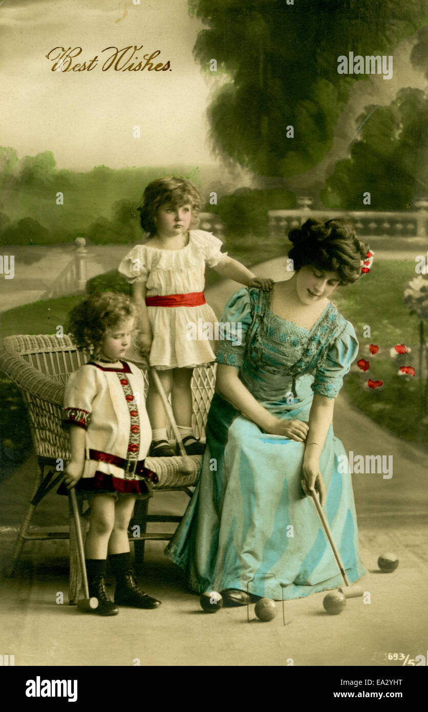 Questa cartolina d'epoca presenta un ritratto di una donna e due bambini, che cattura un momento familiare. L'immagine mette in risalto uno stile artistico tradizionale, con i soggetti presentati in modo classico e senza tempo. Foto Stock