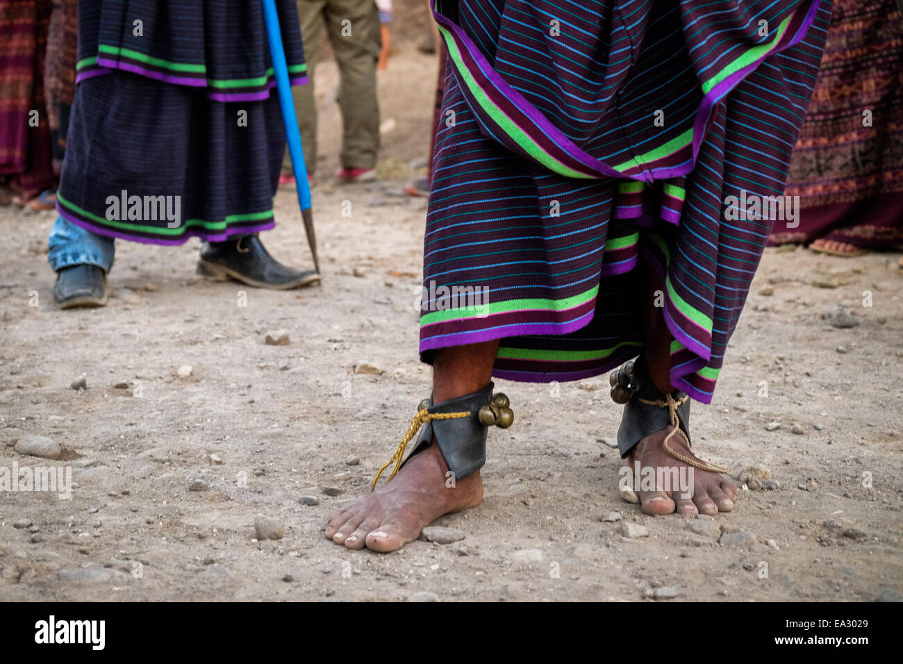 I piedi di uomini locali indossando il tradizionale prodotti tessuti e accessori come essi eseguono una danza tradizionale in Isola di Lembata, Indonesia. Foto Stock