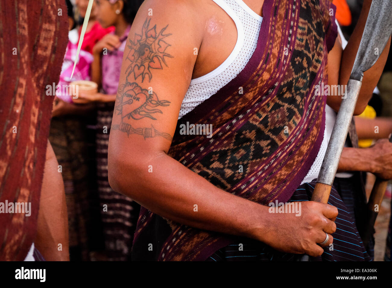 Tatuaggio di un giovane uomo che indossa tradizionali tessuti durante una cerimonia tradizionale nel villaggio Lamagute, Lembata, Indonesia. Foto Stock