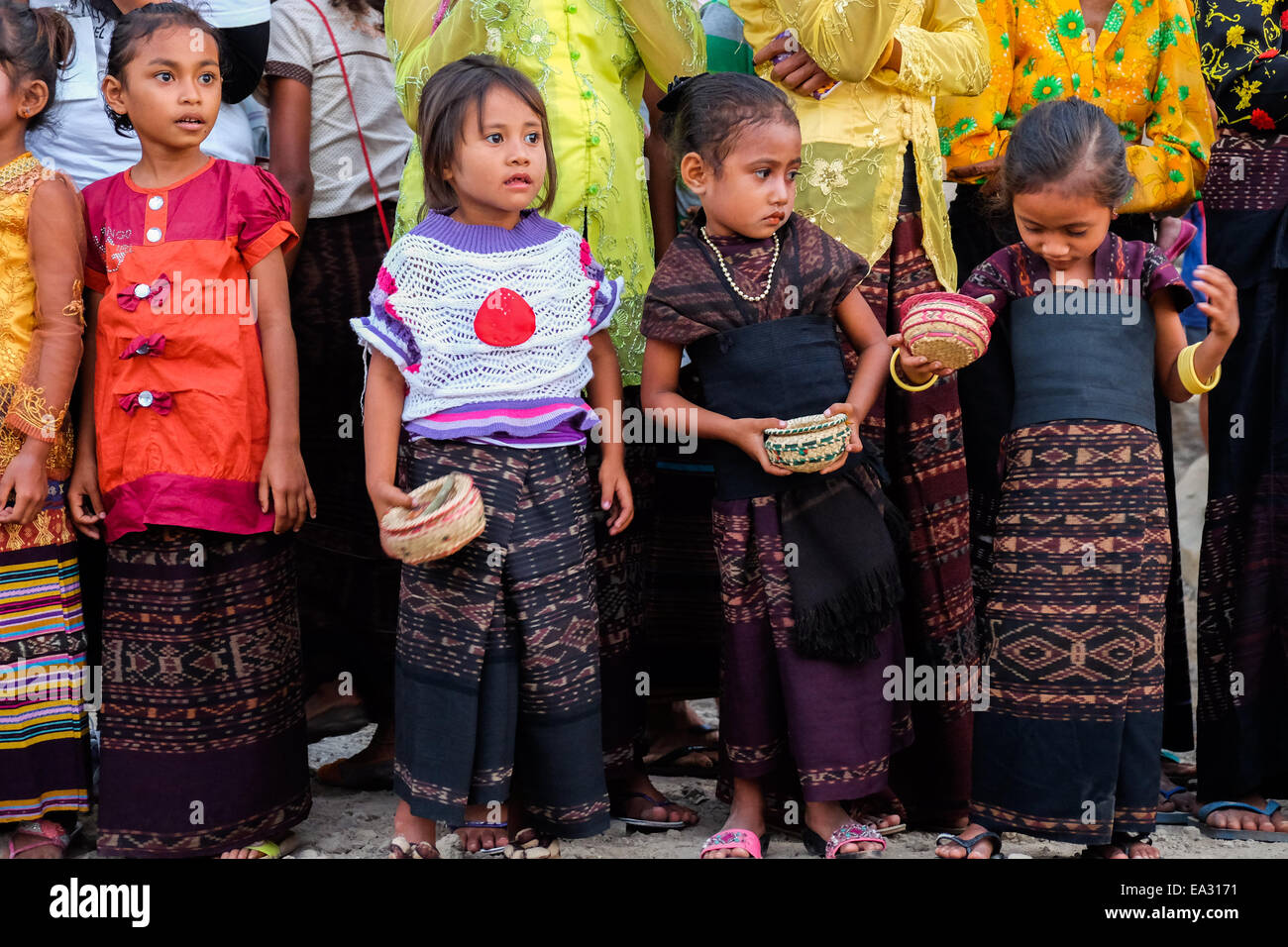 Bambini attendere per gli ospiti in arrivo durante una tradizionale cerimonia di benvenuto nel villaggio Lamagute, Lembata, Indonesia. Foto Stock