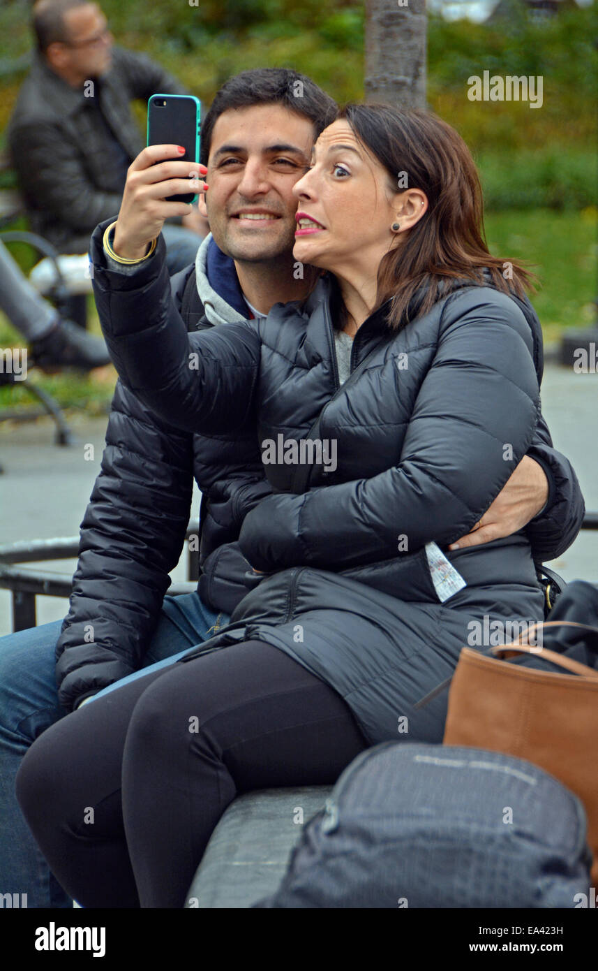 Un giovane facendo facce buffe tenendo un selfie in Washington Square Park nel Greenwich Village, Manhattan New York City Foto Stock