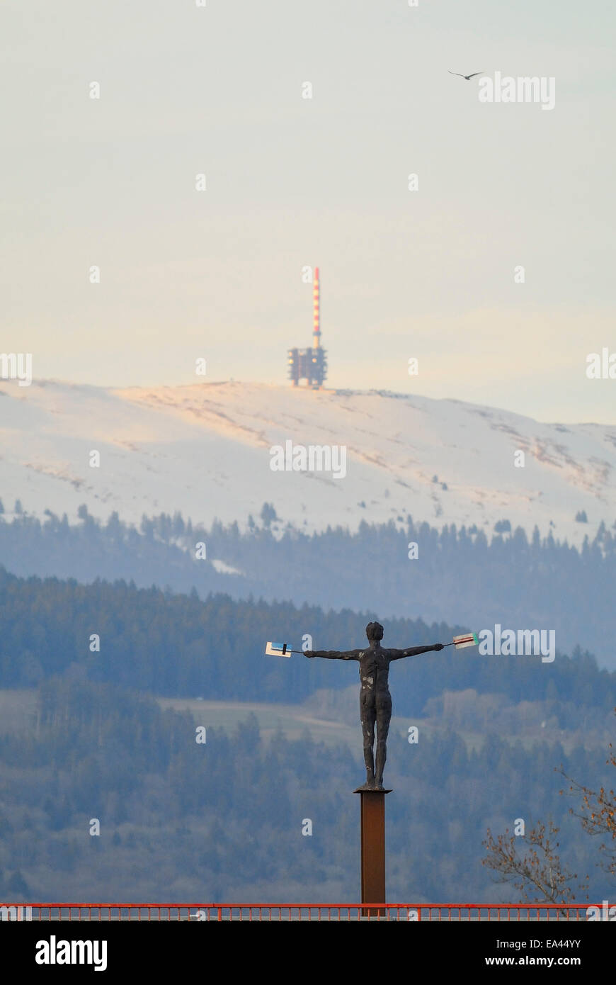 Coperte di neve vertice del Chasseral ridge e torre di telecomunicazioni con Thielle Bridge e statua in primo piano. Foto Stock