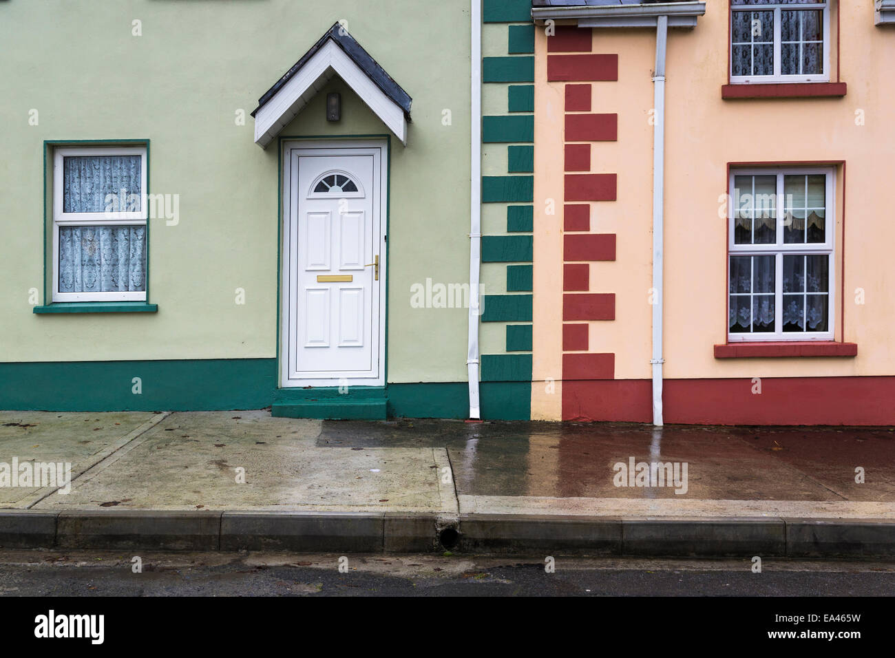 Verde e Rosso e pareti dipinte di case a schiera,Corofin, Co. Clare, Irlanda Foto Stock