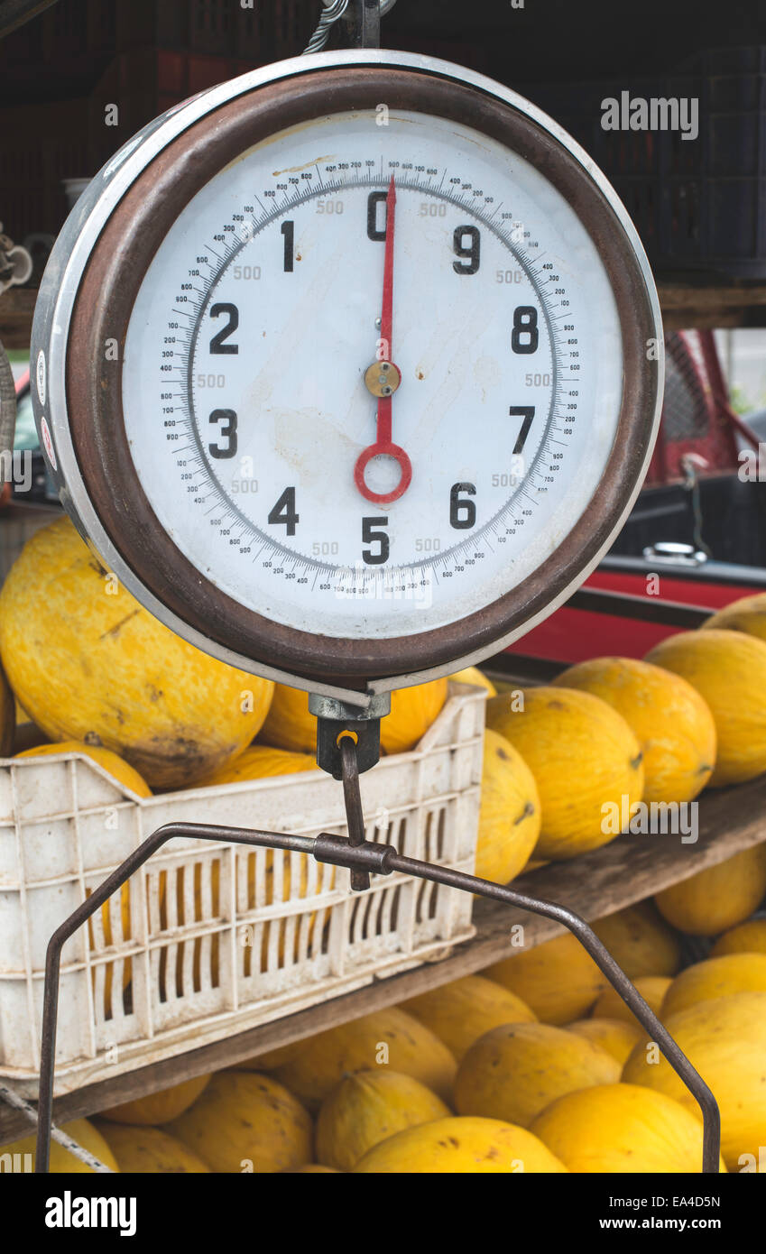 La vendita di meloni sul mercato. Bilancia con pesi Foto Stock