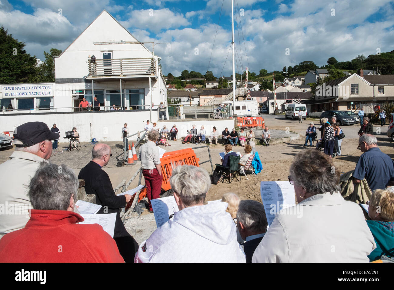 Inni sulla spiaggia.La chiesa cristiana di go-ers approfittare del clima soleggiato cantare canzoni religiose all'aperto,all'aperto,a Ferryside,West Wales, Wales, Regno Unito Foto Stock
