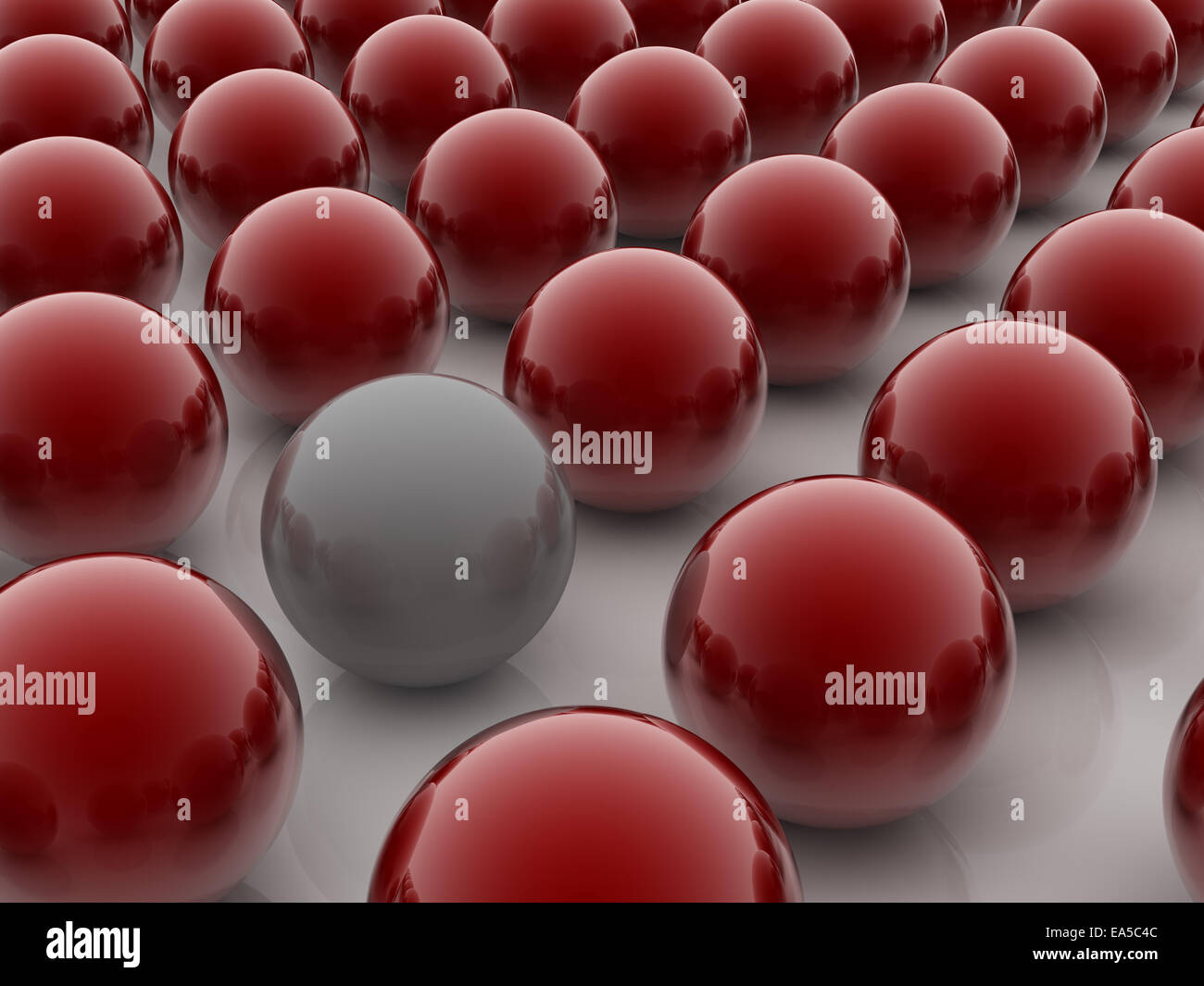 Una sfera di colore grigio posto observably in un gruppo di sfere rosse. Foto Stock