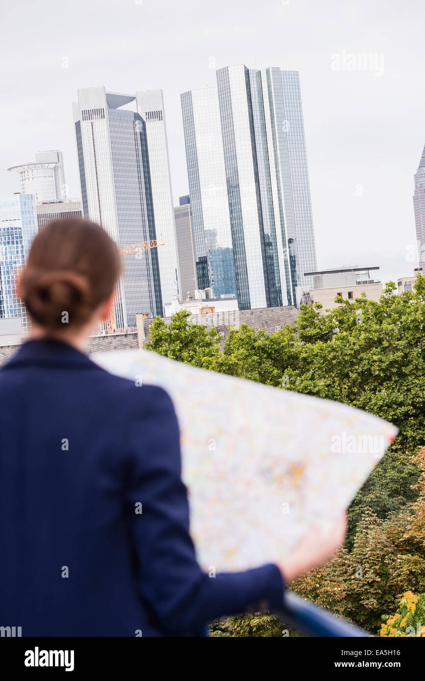 Germania, Hesse, Francoforte, donna che guarda la mappa della città, vista posteriore Foto Stock