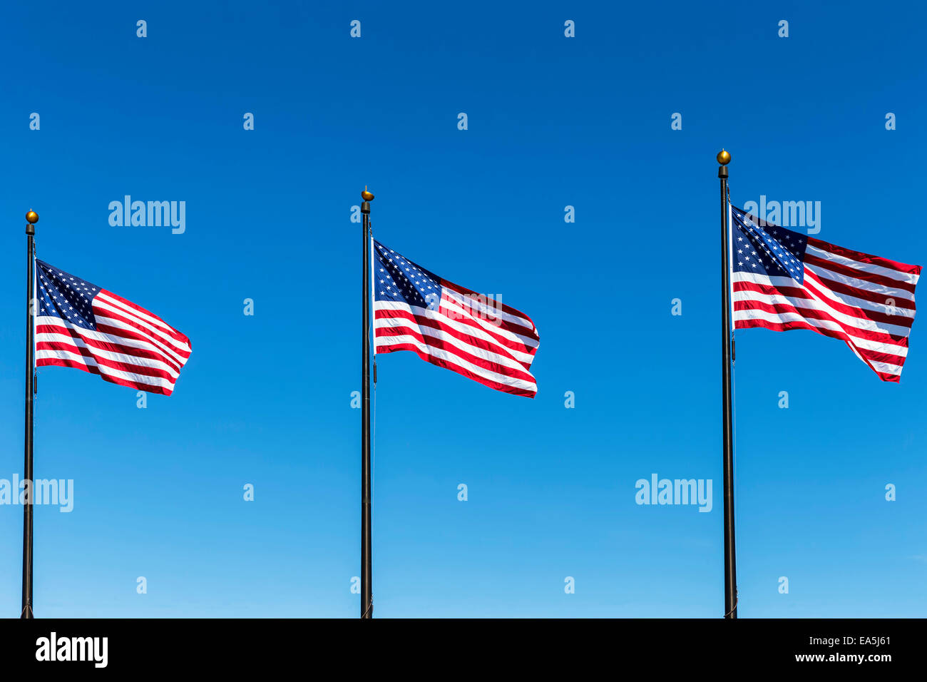 Tre bandierine americane contro il cielo blu Foto Stock