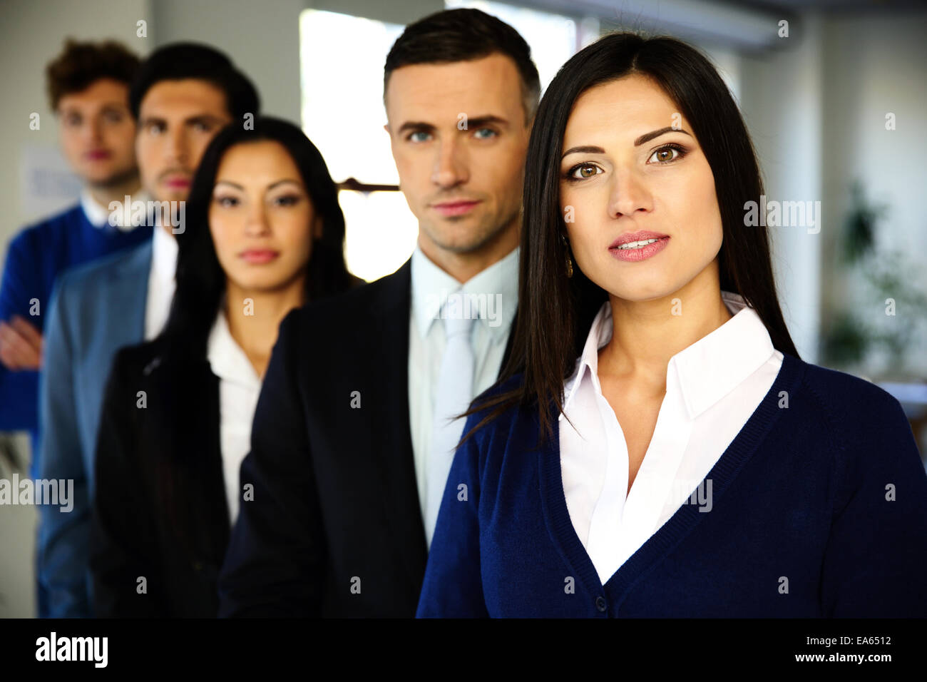 Gruppo di un business persone in piedi allineati in ufficio Foto Stock