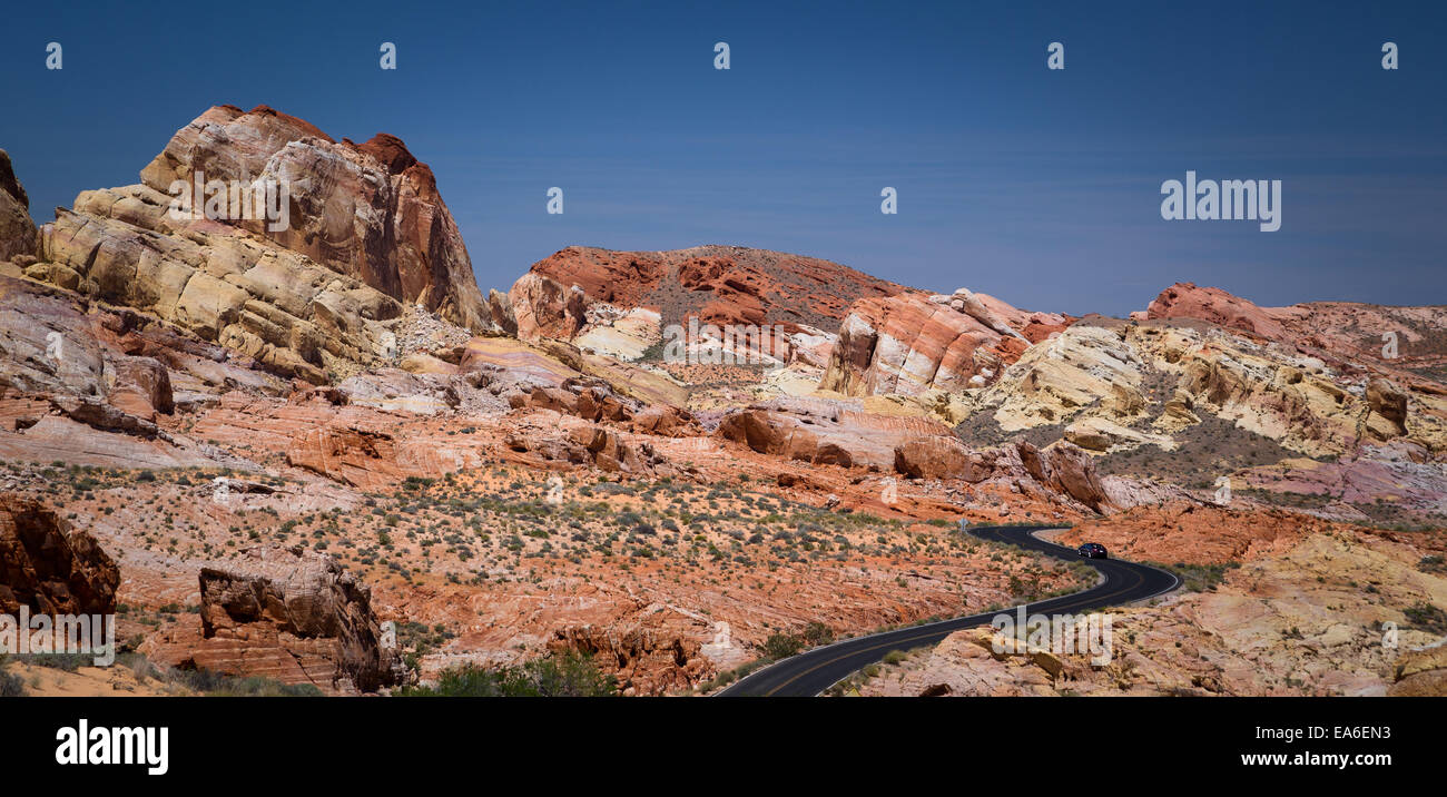 Stati Uniti d'America, Nevada, Clark County, Lone auto sulla strada curva in Valle o Fire State Park Foto Stock