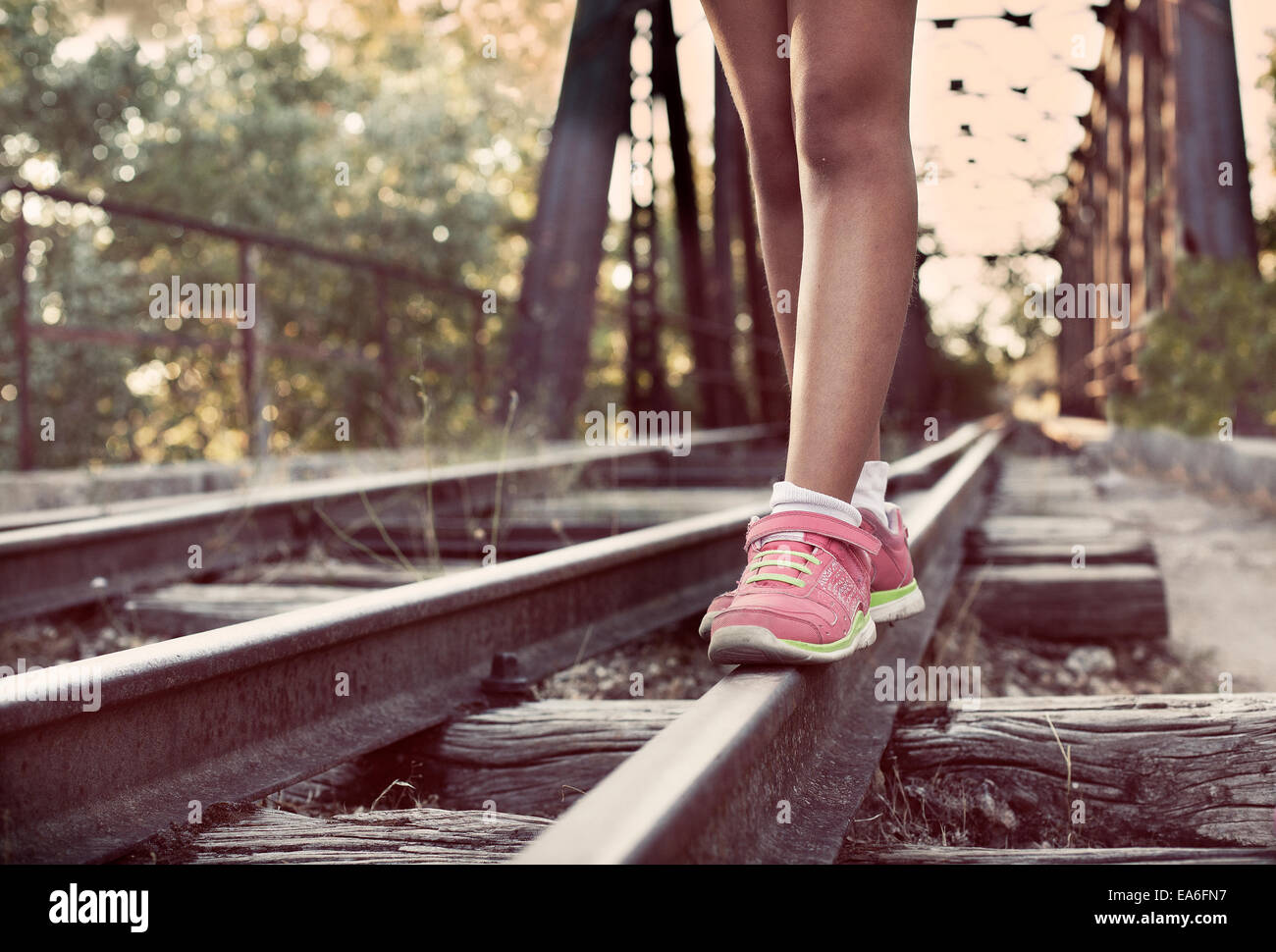 Close-up di donna per le gambe a piedi lungo i binari del treno Foto Stock