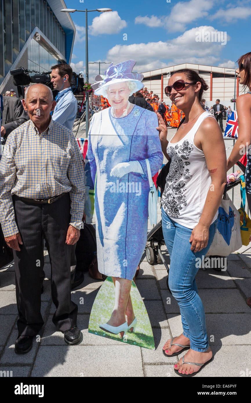 L uomo e la donna pongono con un ritaglio di cartone della Regina Elisabetta II all'apertura ufficiale della lettura stazione ferroviaria. Foto Stock