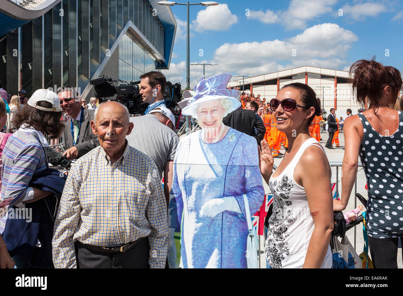 L uomo e la donna pongono con un ritaglio di cartone della Regina Elisabetta II all'apertura ufficiale della lettura stazione ferroviaria. Foto Stock