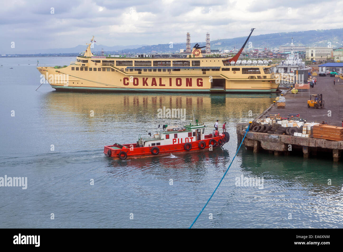 Cokaliong traghetto è attraccata a Cebu City Harbour wharf e un pilota di barca si avvicina il dock. Foto Stock