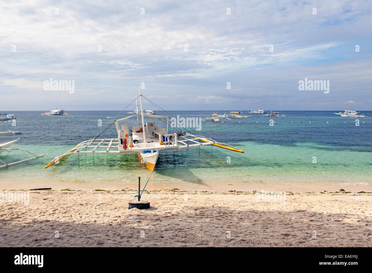 Un immersioni completamente attrezzato outrigger imbarcazione a vela è ancorato alla struttura Alona Beach in Panglao Island, Bohol, isole filippine. Foto Stock