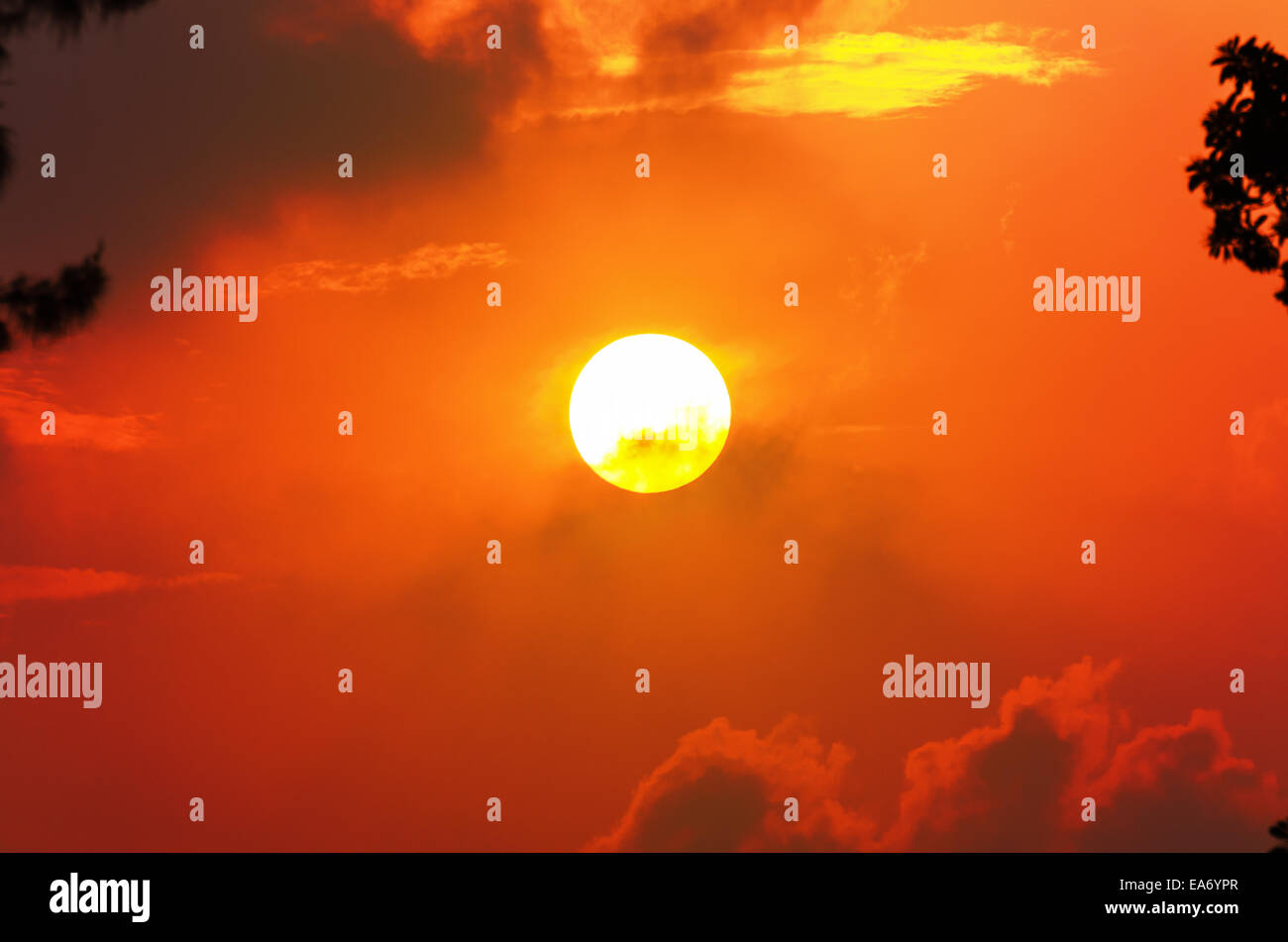 Il sole e la nuvola in cielo con un luminoso bagliore arancione al tramonto Foto Stock