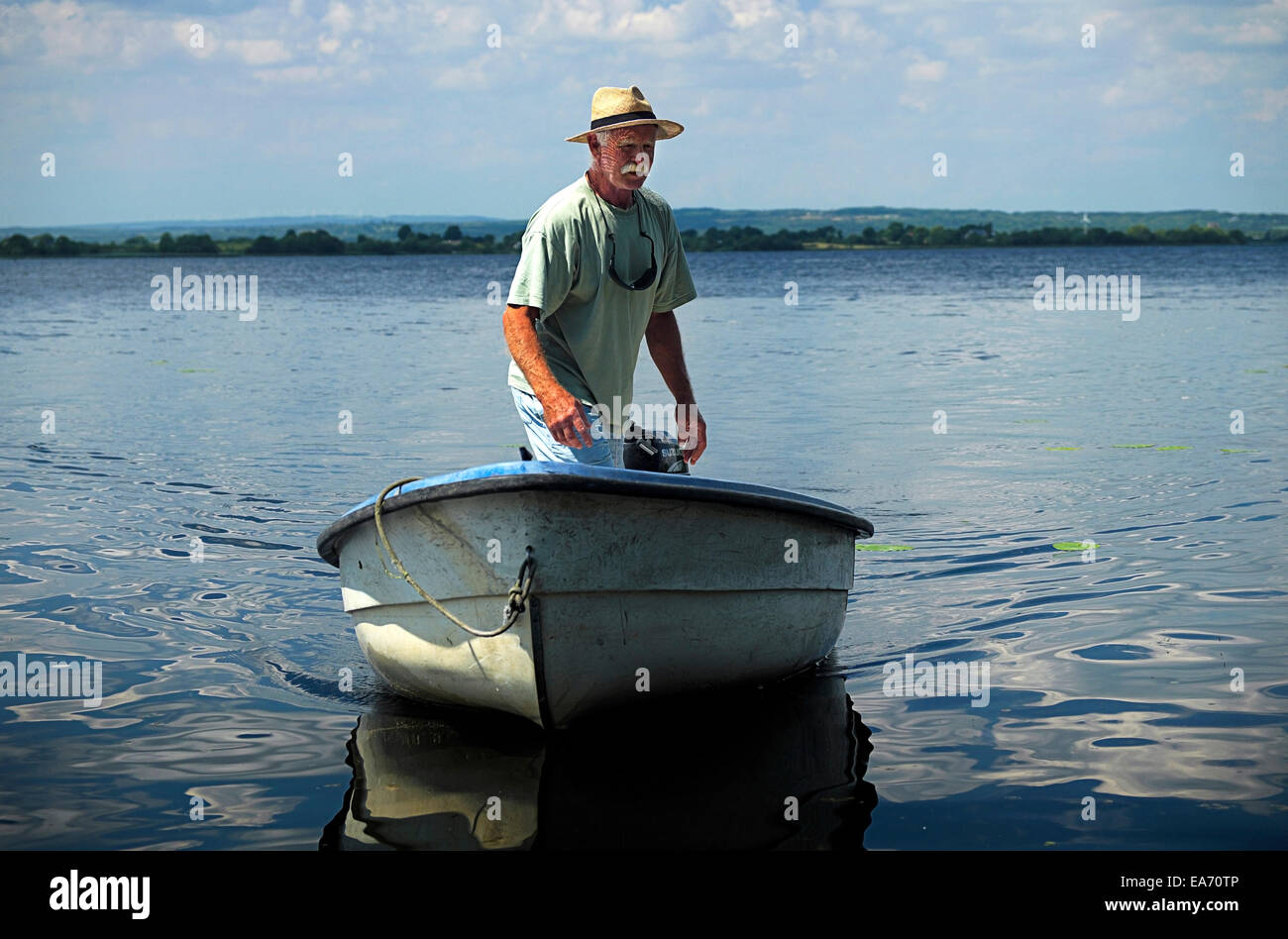 L uomo e la barca a Lough Derg Foto Stock