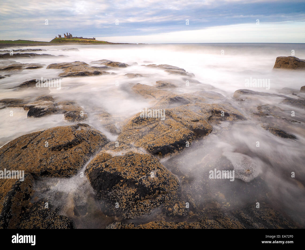 Incredibilmente aspra costa di Isola Santa in Northumberland è protetto da Lindisfarne Castle su un bellissimo morni inverni Foto Stock