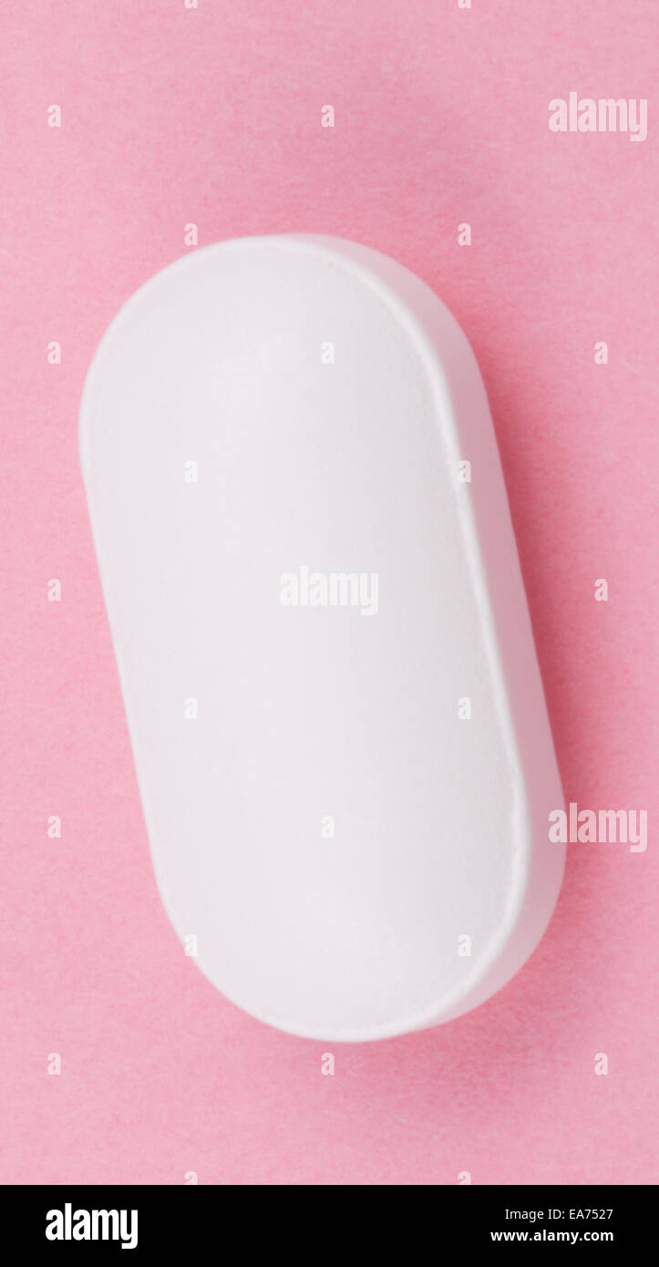 Pillola bianco su sfondo rosa Foto Stock