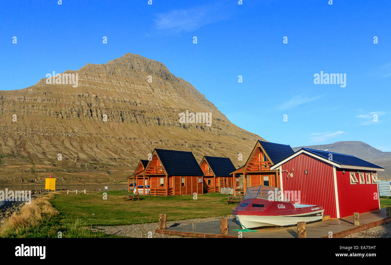 Cabine nella piccola cittadina di Eskifjordur a Mjoeyri Guesthouse in Islanda Orientale. La barca è una vasca calda. Foto Stock