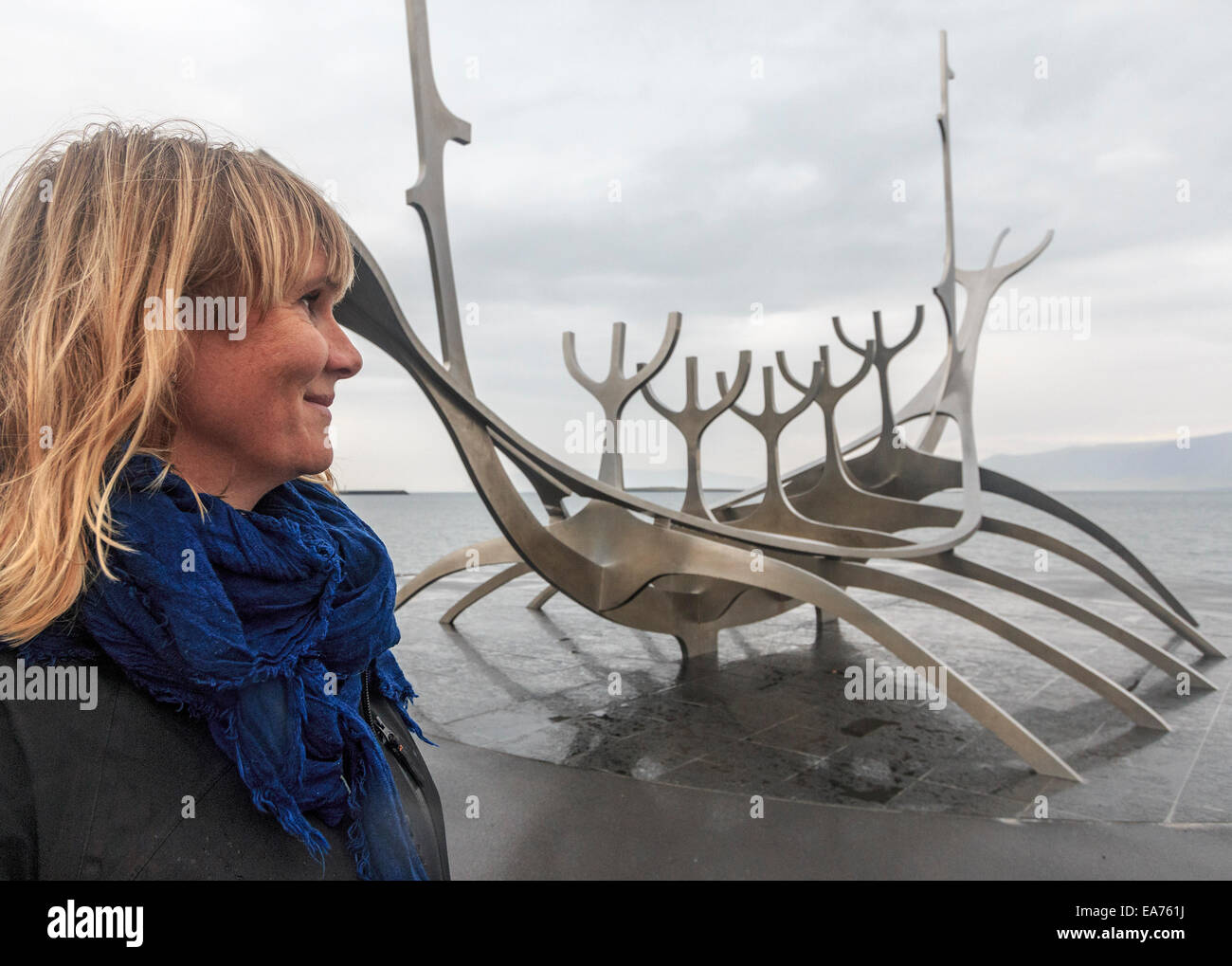 Donna guarda a Sun Voyager (Sólfar) è una scultura di metallo da Jón Gunnar Árnason seduti lungo il litorale di Reykjavik Foto Stock