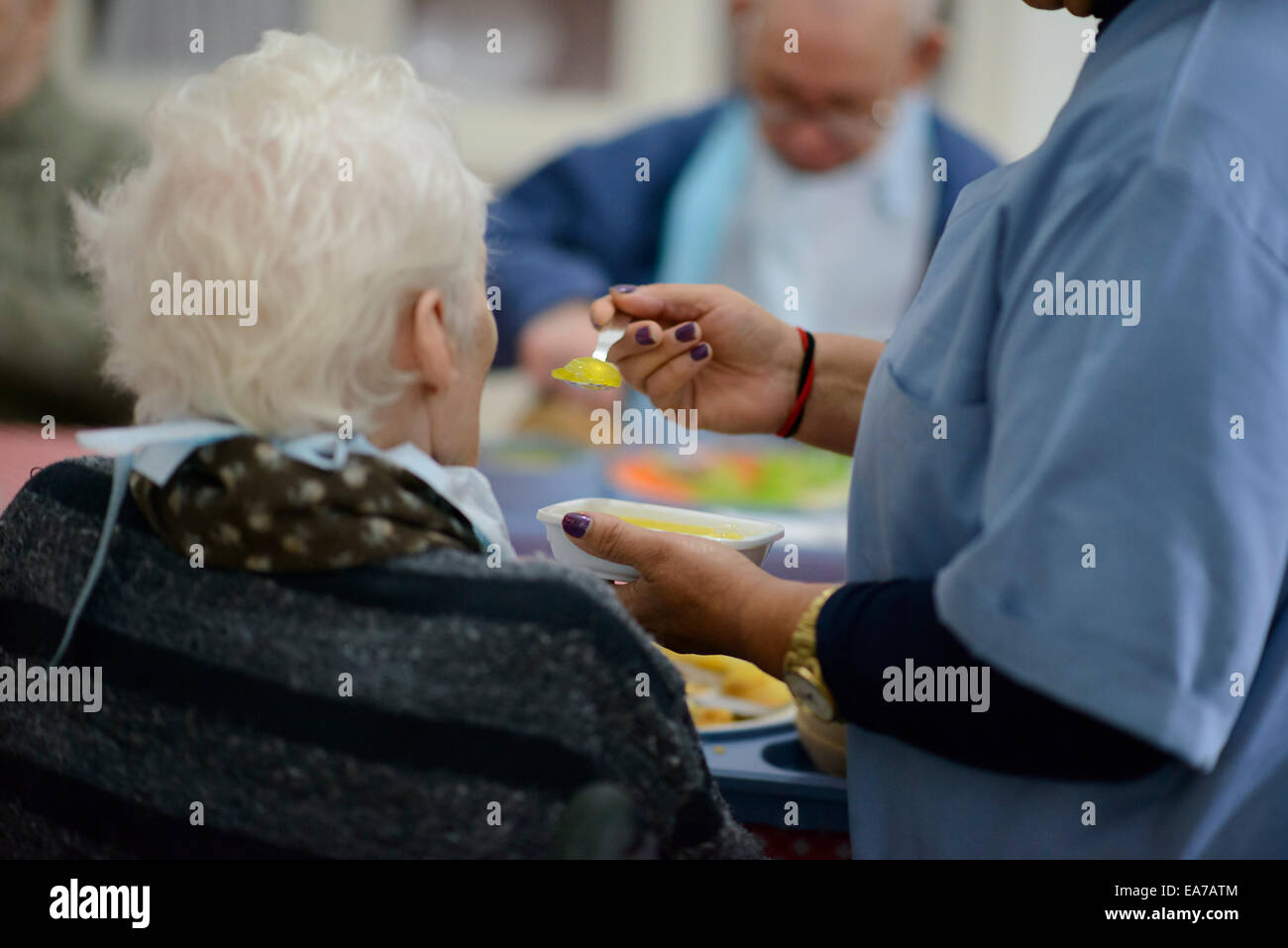 Assistente sociale alimentazione di una donna anziana in una casa di cura Foto Stock