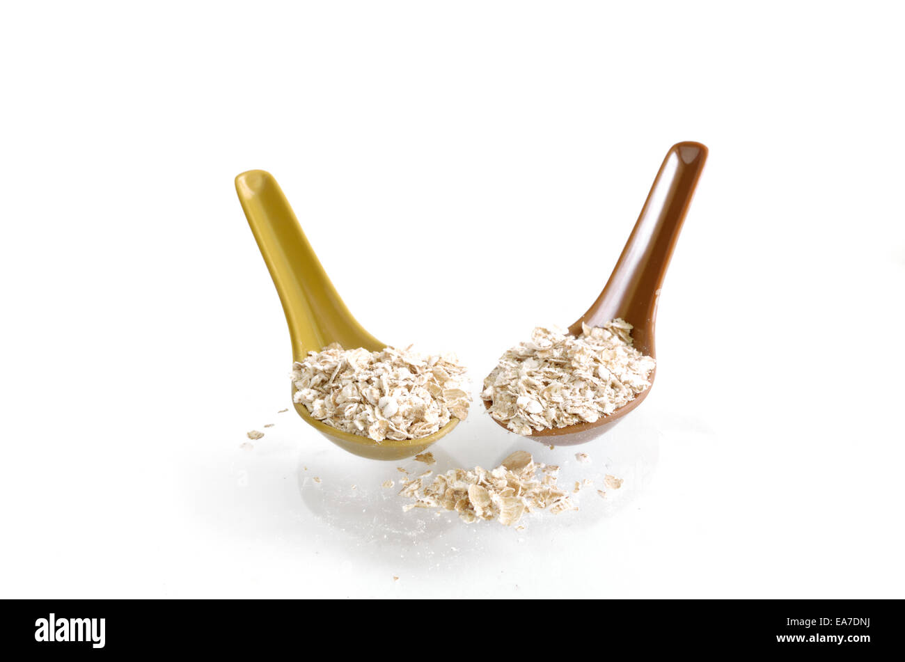 Fiocchi di avena con cucchiaio isolato su bianco Foto Stock