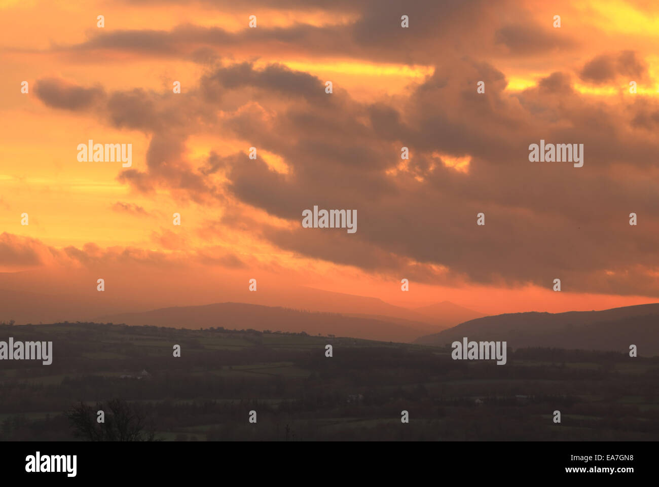 Dawn rising con colori brillanti su un paesaggio del Parco Nazionale di Brecon Beacons, con le nuvole e cieli dorati Foto Stock