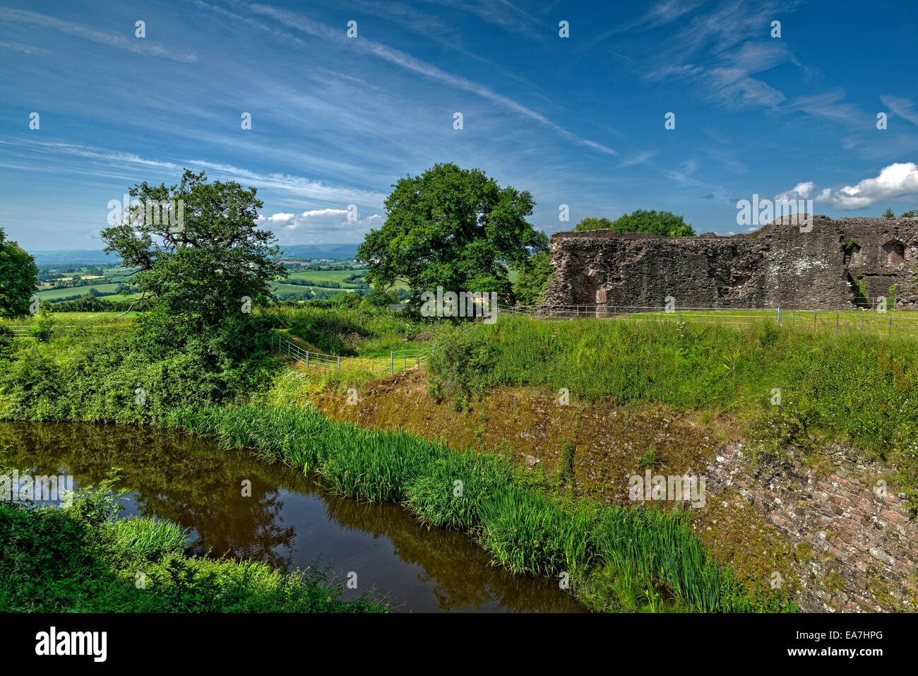 Riempito di acqua fossato e parte della parete esterna del castello bianco, vicino Aberagvenny Foto Stock