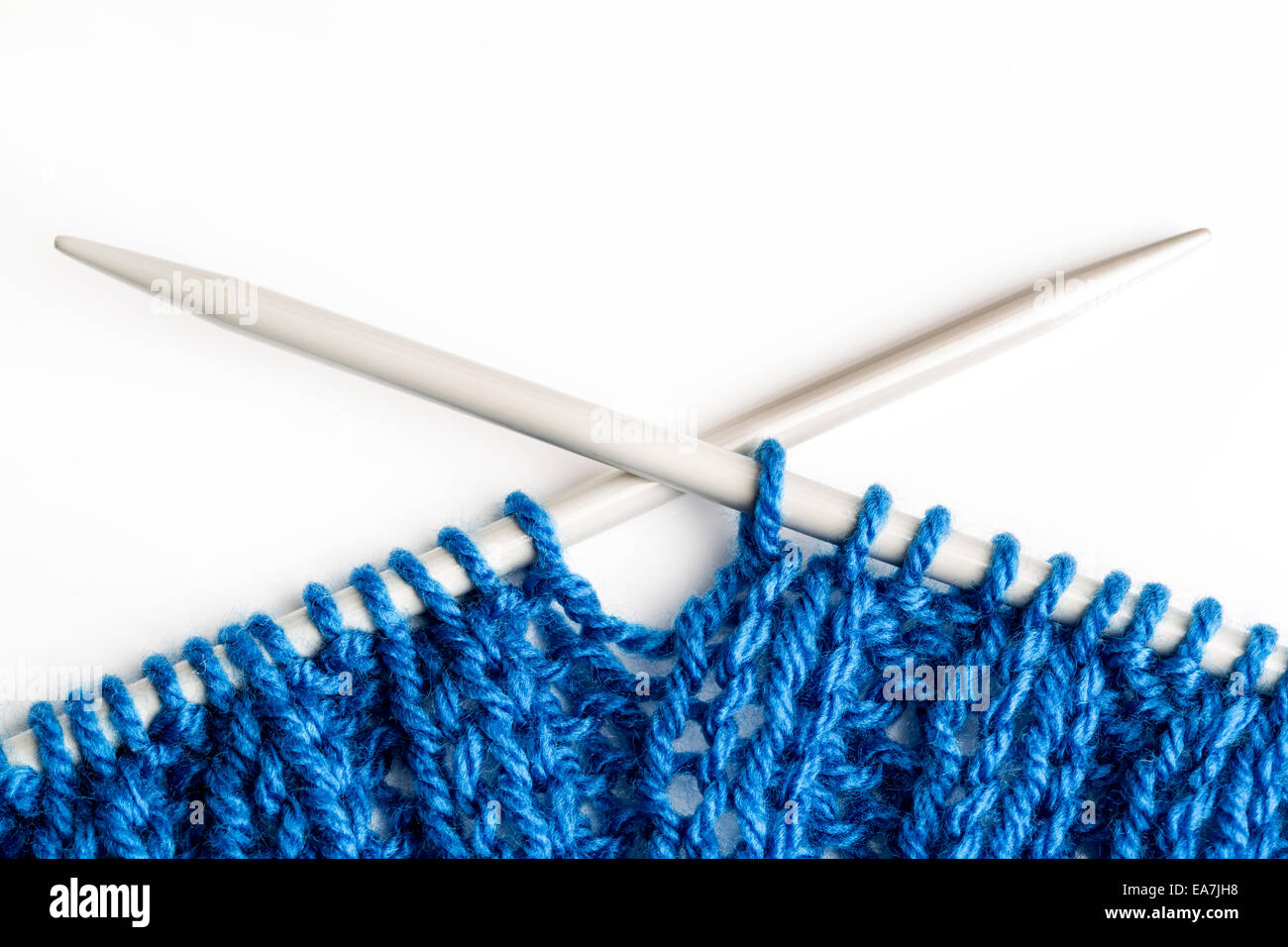 Primo piano di una blu sciarpa lavorata a maglia davanti a uno sfondo bianco Foto Stock