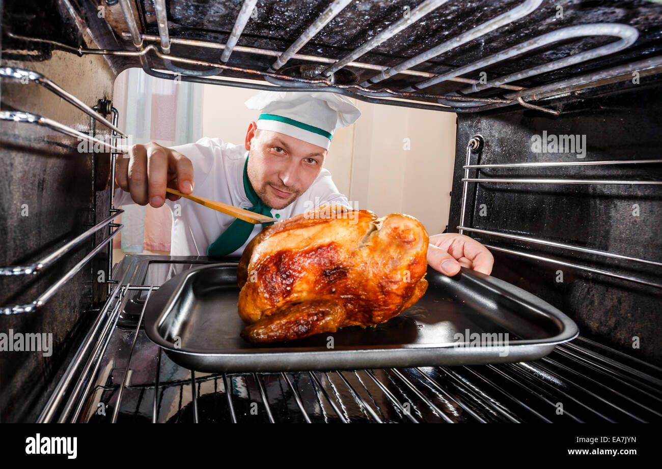Lo chef prepara il pollo arrosto nel forno, vista dall'interno del forno.  Per la cottura in forno Foto stock - Alamy