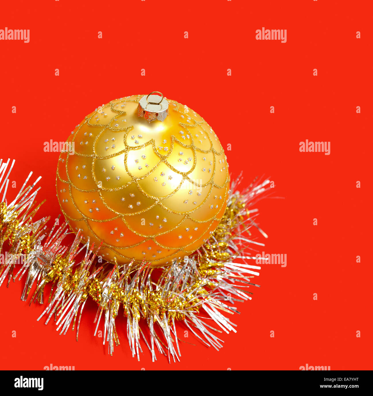 Golden ornamento di Natale e la ghirlanda forte su sfondo rosso Foto Stock